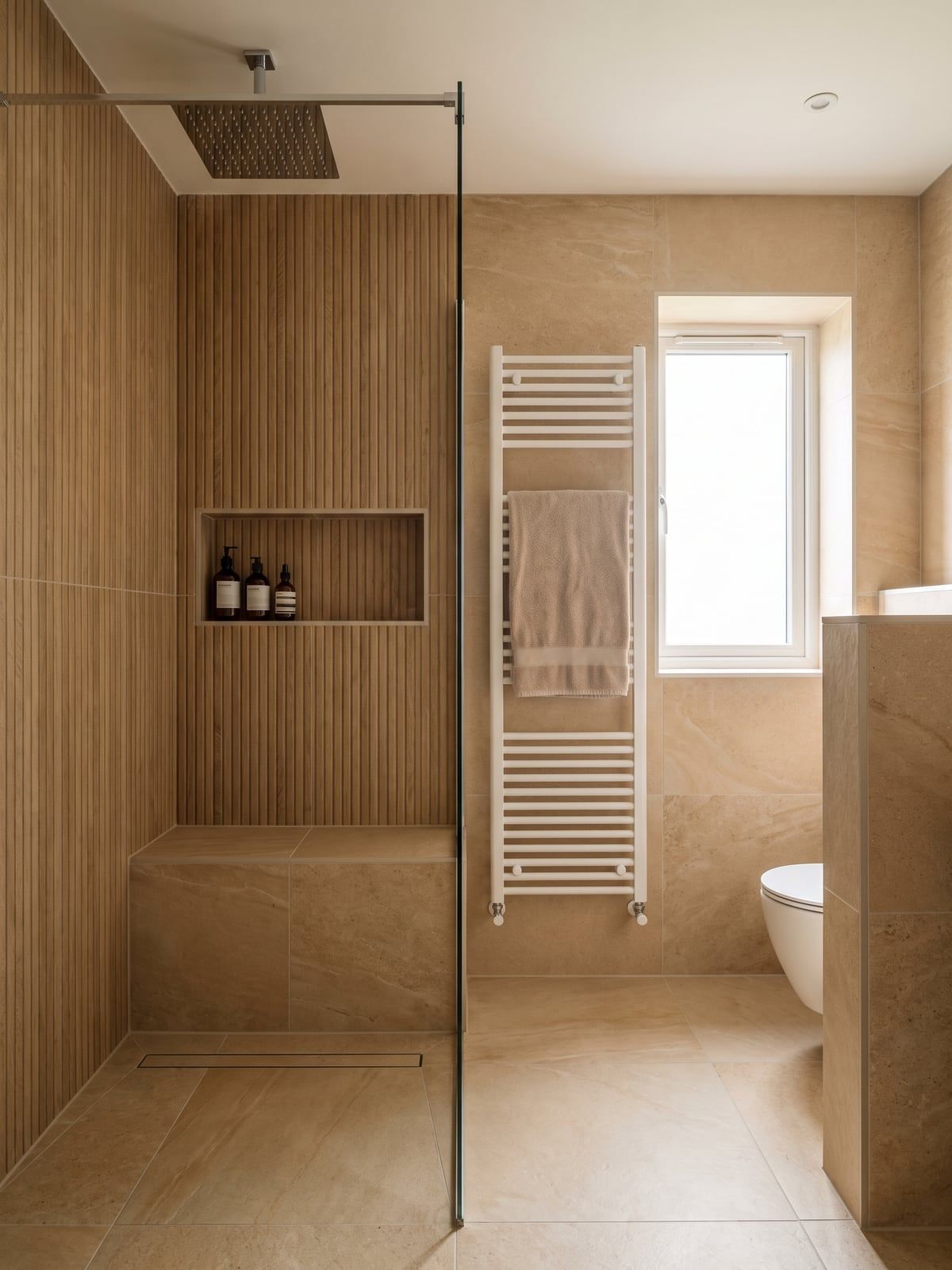 Bathroom with a fluted oak-effect wall in the shower, a ceiling rain shower and a white towel radiator by the window